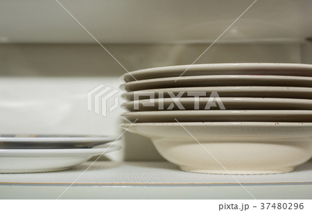 Stacked plates in the kitchen cupboard 37480296