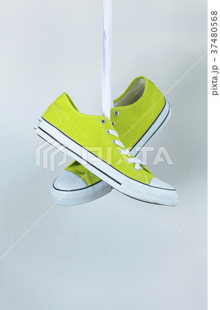 Pair of new green sneakers hanging on the wall Pair of new green sneakers hanging on the wall 37480568