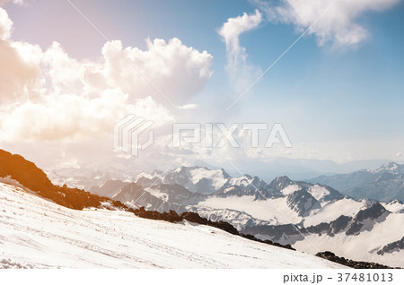 Dark blue sky with clouds on the rocky peaks of 37481013