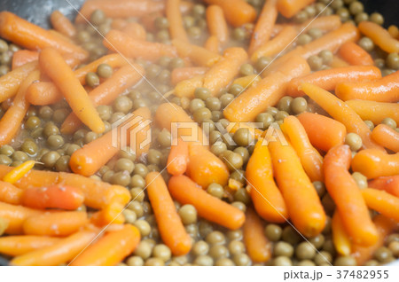 closeup of green peas and carrots in stove 37482955