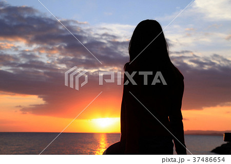 夕日を眺める女性の写真素材