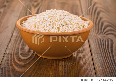 raw white rice in a Cup on a wooden table. 37486745