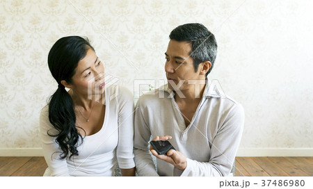 スマホ片手に話をする仲良し夫婦 スマホ片手に話をする仲良し夫婦 37486980