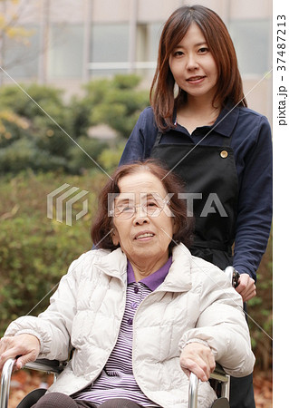 車いすに乗る老人と介護士 車いすに乗る老人と介護士 37487213