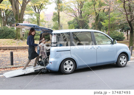 福祉車両に車椅子の老人を乗せる介護士 37487493