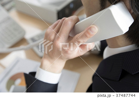 オフィスで電話に出るビジネスマン手元 37487744