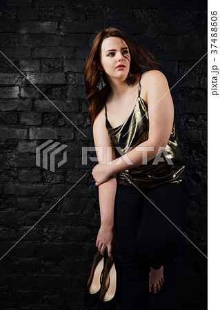 plus size model in a gold blouse and black jeans 37488606