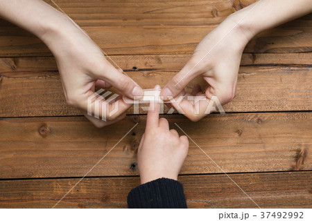 子供の手に絆創膏を貼る母の手 37492992