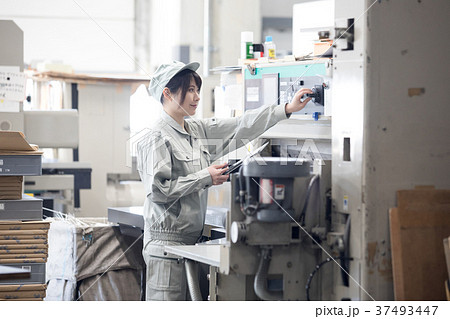 町工場・機械を操作する若い女性作業員 37493447