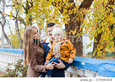 a family with a boy walking in the autumn Park 37496568