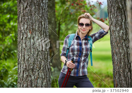 young woman with nordic walk pols 37502940