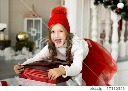 Happy girl holding a big box with a gift Happy girl holding a big box with a gift 37510596