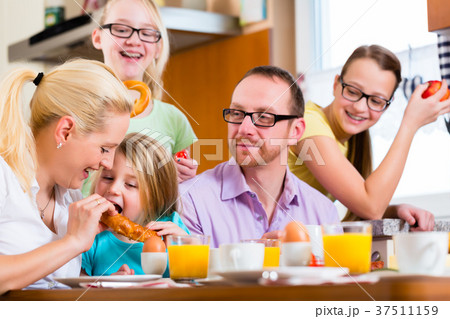 Family in kitchen having breakfast together Family in kitchen having breakfast together 37511159