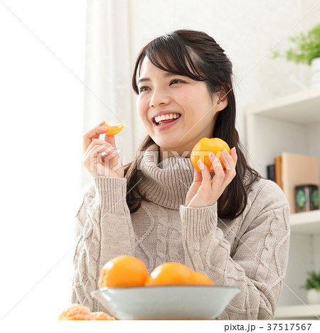 みかんを食べる女性の写真素材