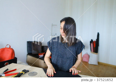 Girl working with belt at clothing repair. 37521652