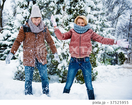 Carefree friends playing with snow in forest Carefree friends playing with snow in forest 37525955