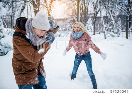 Carefree young man and woman playing snowballs Carefree young man and woman playing snowballs 37526042