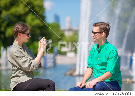 Young girl taking a picture of boyfriend while Young girl taking a picture of boyfriend while 37526832