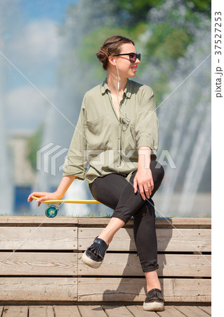 Portrait of happy young urban girl with skateboard Portrait of happy young urban girl with skateboard 37527253