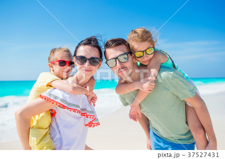 Closeup happy family of four on beach vacation Closeup happy family of four on beach vacation 37527431