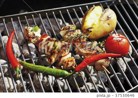 Pork kebabs and vegetables on barbecue rack 37530646