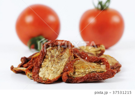 Dried tomatoes in front of fresh tomatoes 37531215