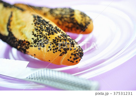 Poppy seed baguettes on glass plate 37531231