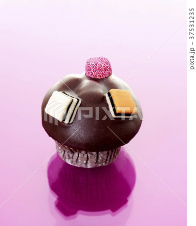 Muffin with chocolate icing and liquorice allsorts 37531235