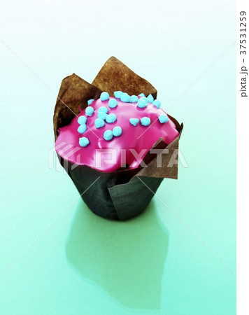 Muffin with pink icing in baking parchment 37531259