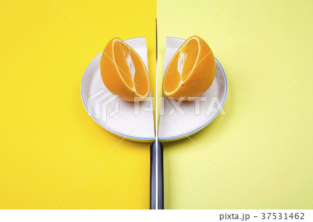 Orange halves with knife on halved plate 37531462