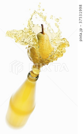 Pear juice splashing out of bottle Pear juice splashing out of bottle 37531998