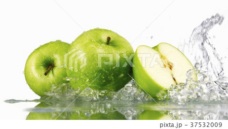 Green apples, whole and halved, with splashing water 37532009