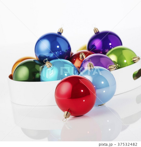 Shiny, coloured Christmas baubles on tray 37532482