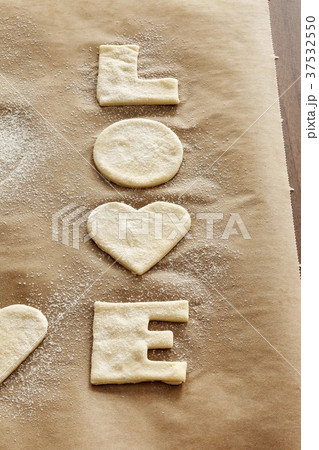 Cut-out 'LOVE' biscuits on baking parchment 37532550