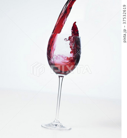 Pouring red wine into a glass (splash) 37532619
