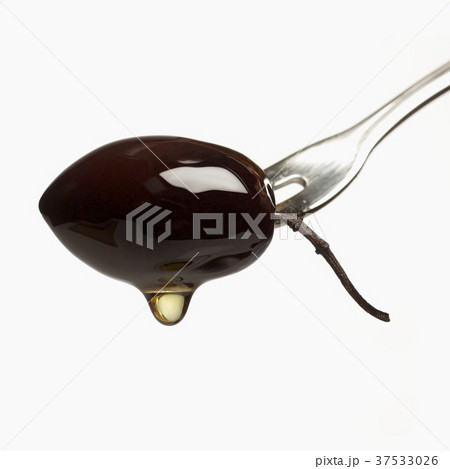 Olive oil dripping from olive on fork Olive oil dripping from olive on fork 37533026