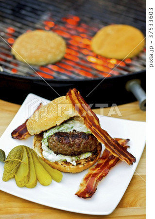 Barbecued hamburger with bacon and gherkin 37533603