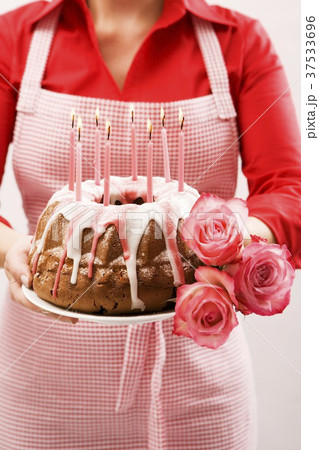 Woman holding ring cake and roses for a birthday 37533696