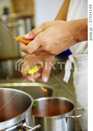 Chef in commercial kitchen peeling carrots Chef in commercial kitchen peeling carrots 37534149