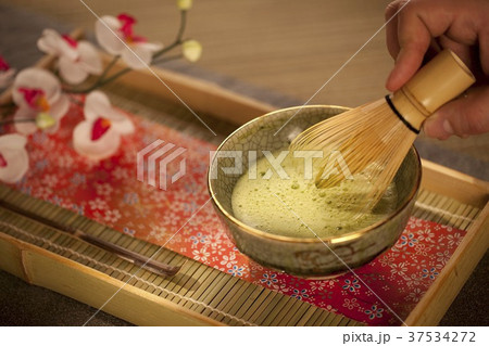 Mixing Japanese Matcha Green Tea in a Ceremonial Bowl with Whisk 37534272