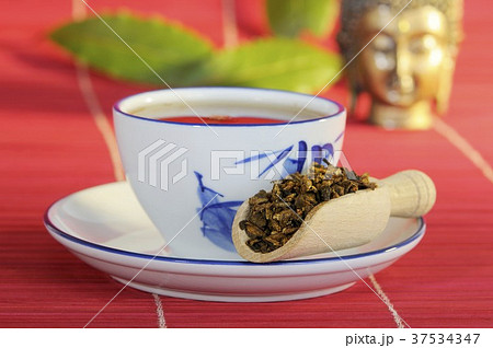 Rhubarb root in wooden scoop with tea Rhubarb root in wooden scoop with tea 37534347