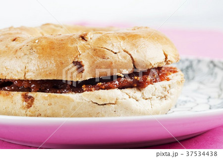 Cinnamon and raisin bagel with fig jam (close-up) Cinnamon and raisin bagel with fig jam (close-up) 37534438