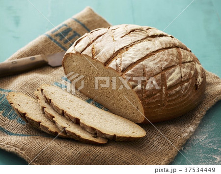 Loaf of bread, partly sliced, on jute sack Loaf of bread, partly sliced, on jute sack 37534449