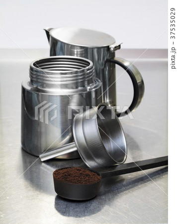 Espresso maker and scoop full of ground coffee 37535029