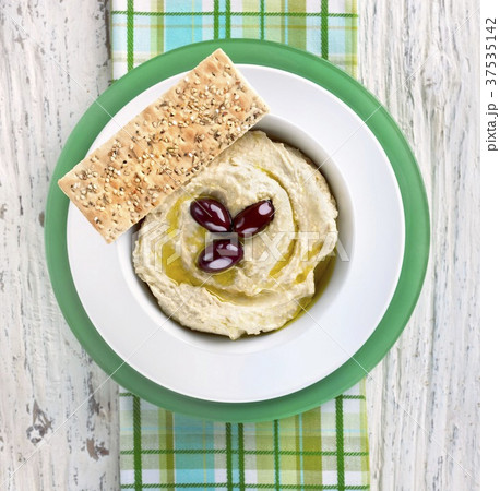 Hummus with Olive Oil and Olives in a Bowl with Sesame Seed Flat Bread Hummus with Olive Oil and Olives in a Bowl with Sesame Seed Flat Bread 37535142
