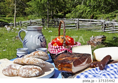 A picnic and alpine meadow with bread, bacon, cheese, sausages, tomatoes and wine A picnic and alpine meadow with bread, bacon, cheese, sausages, tomatoes and wine 37535442