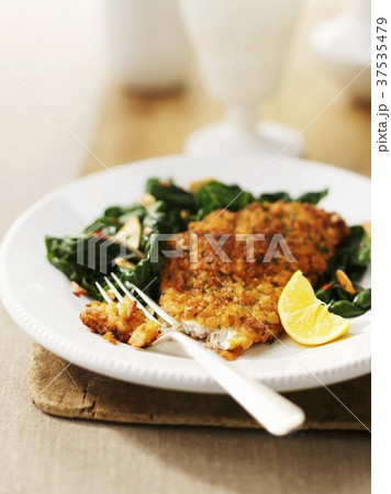 A breaded fish fillet with spinach A breaded fish fillet with spinach 37535479