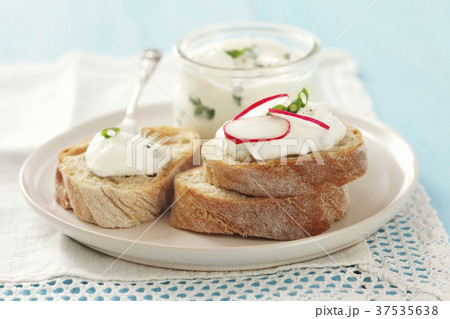 Slices of bread topped with chive quark and radishes 37535638