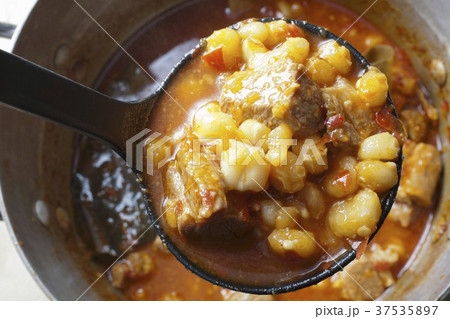 Red Posole; Mexican Hominy Stew; Made with Pork; In Ladle Above Pot 37535897