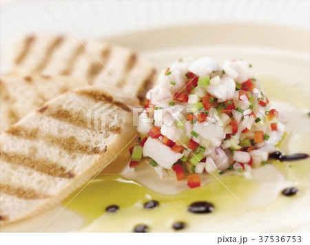 Citrus Ceviche of Bass Fish with Grilled Bread on a White Plate 37536753